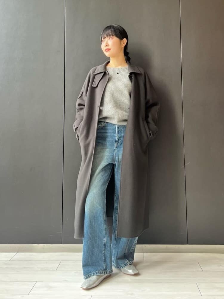 ニットにデニムパンツをあわせた女性