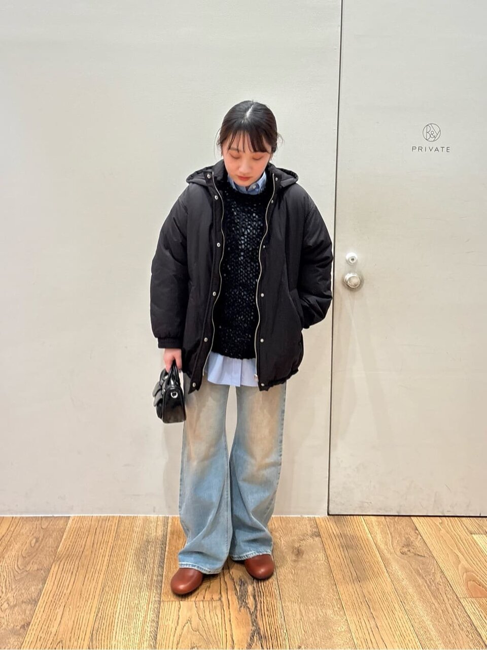 ニットにデニムパンツをあわせた女性