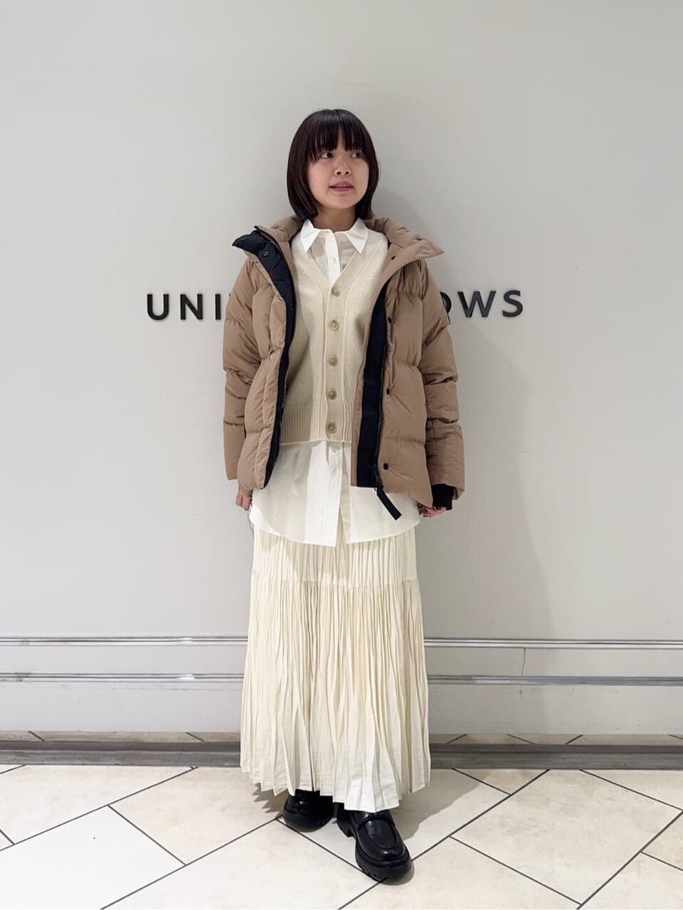 シャツとカーディガンをレイヤードした女性