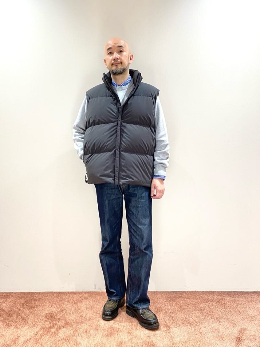 ダークグリーンのダウンベストを着た男性
