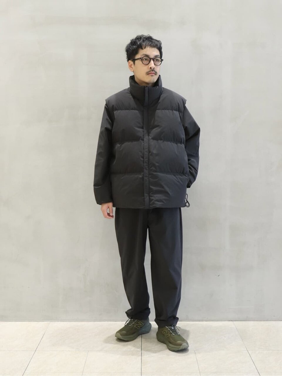 オリーブカラーのダウンベストを着た男性