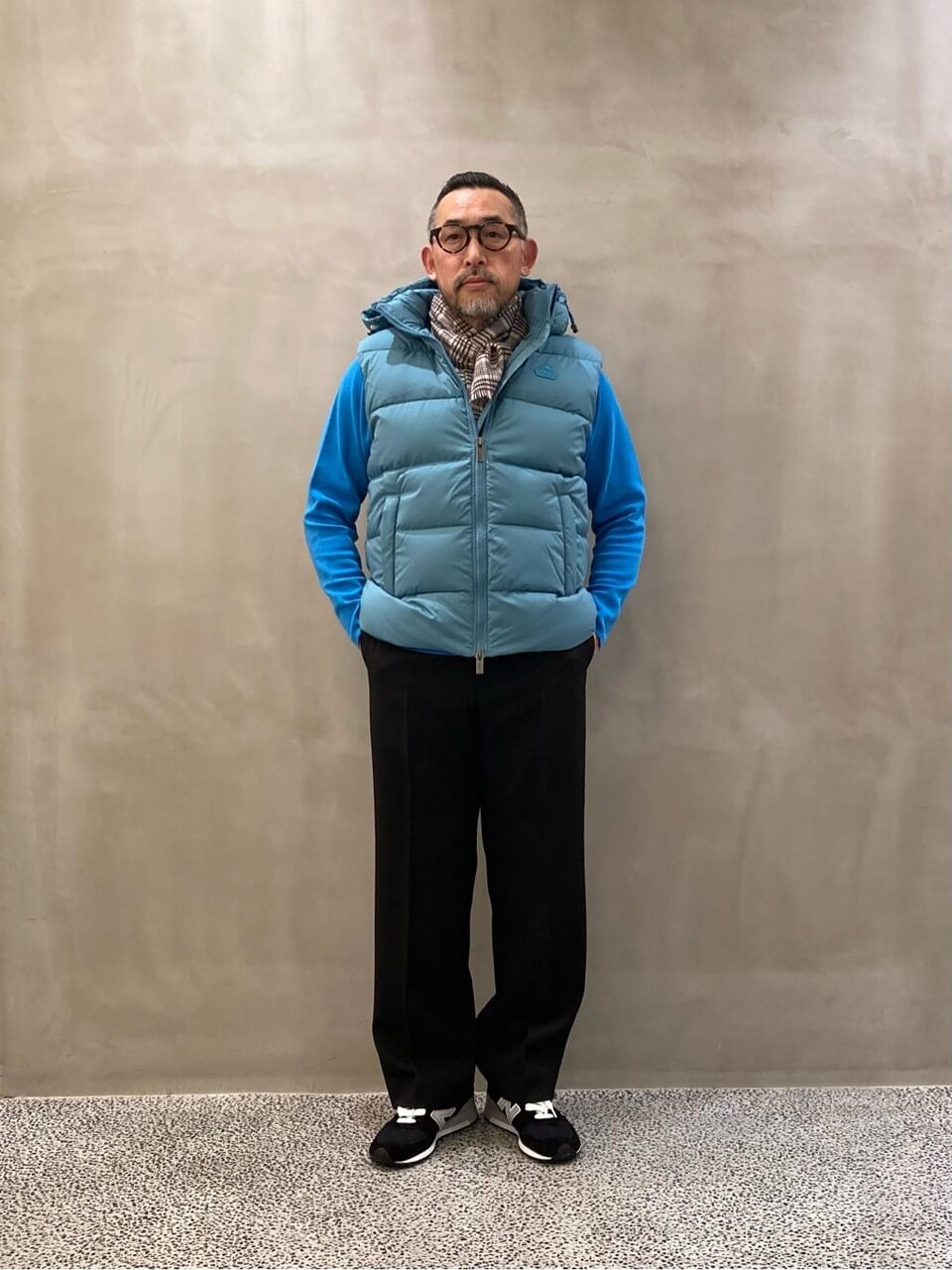 ターコイズブルーのダウンベストを着た男性