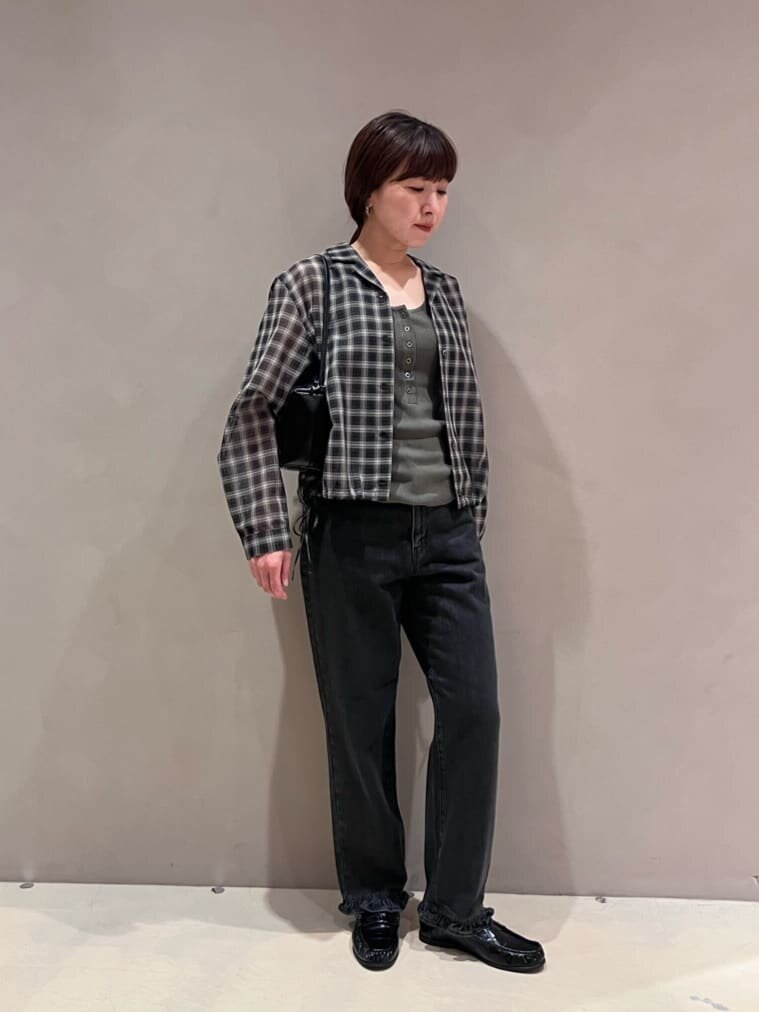 チェック柄シャツとデニムパンツを着た女性