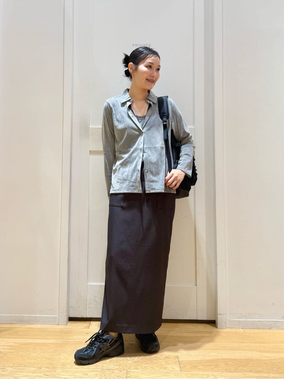 グレーのシャツとタイトスカートを着た女性