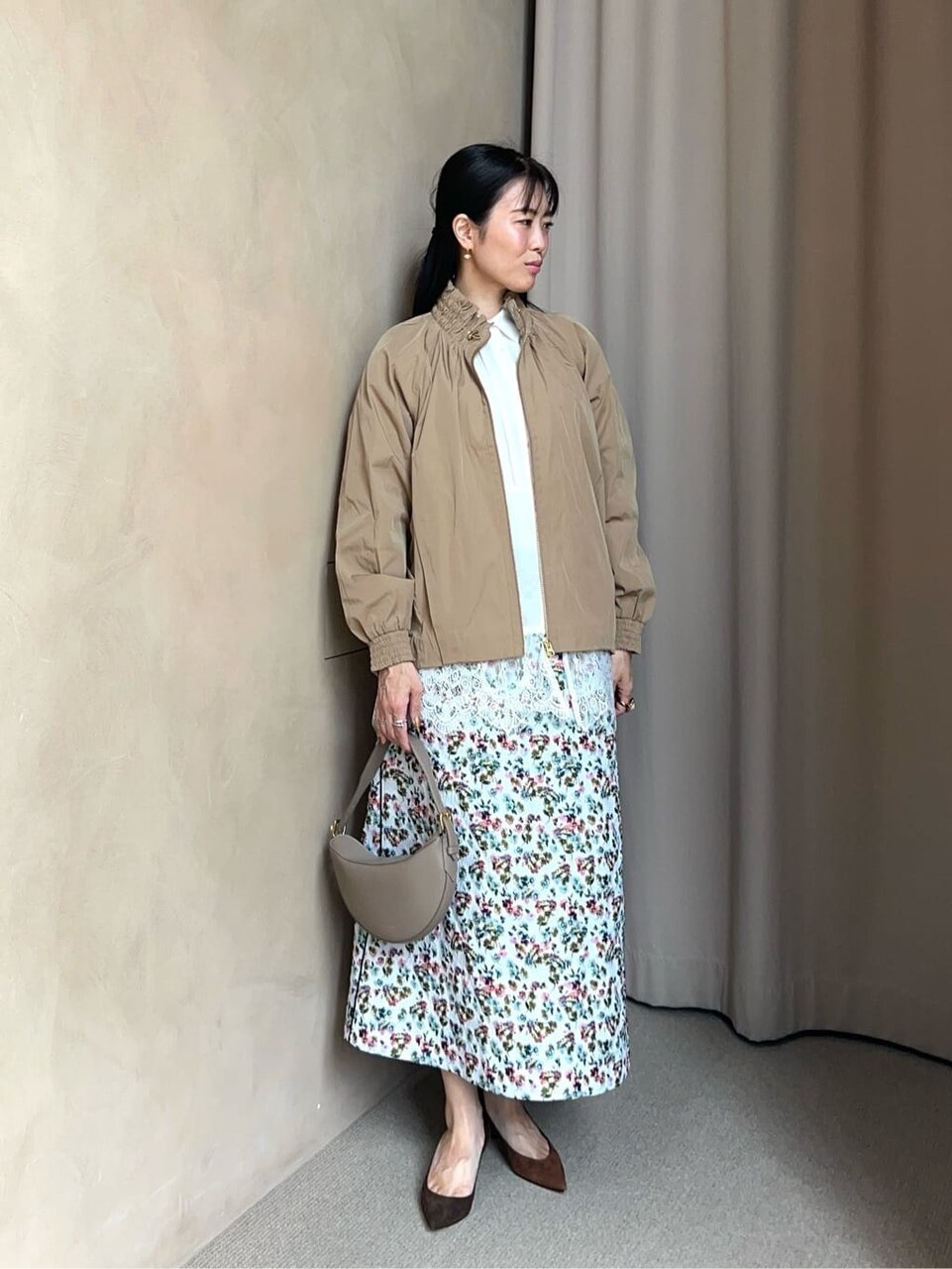 ギャザーブルゾンと花柄スカートを着た女性