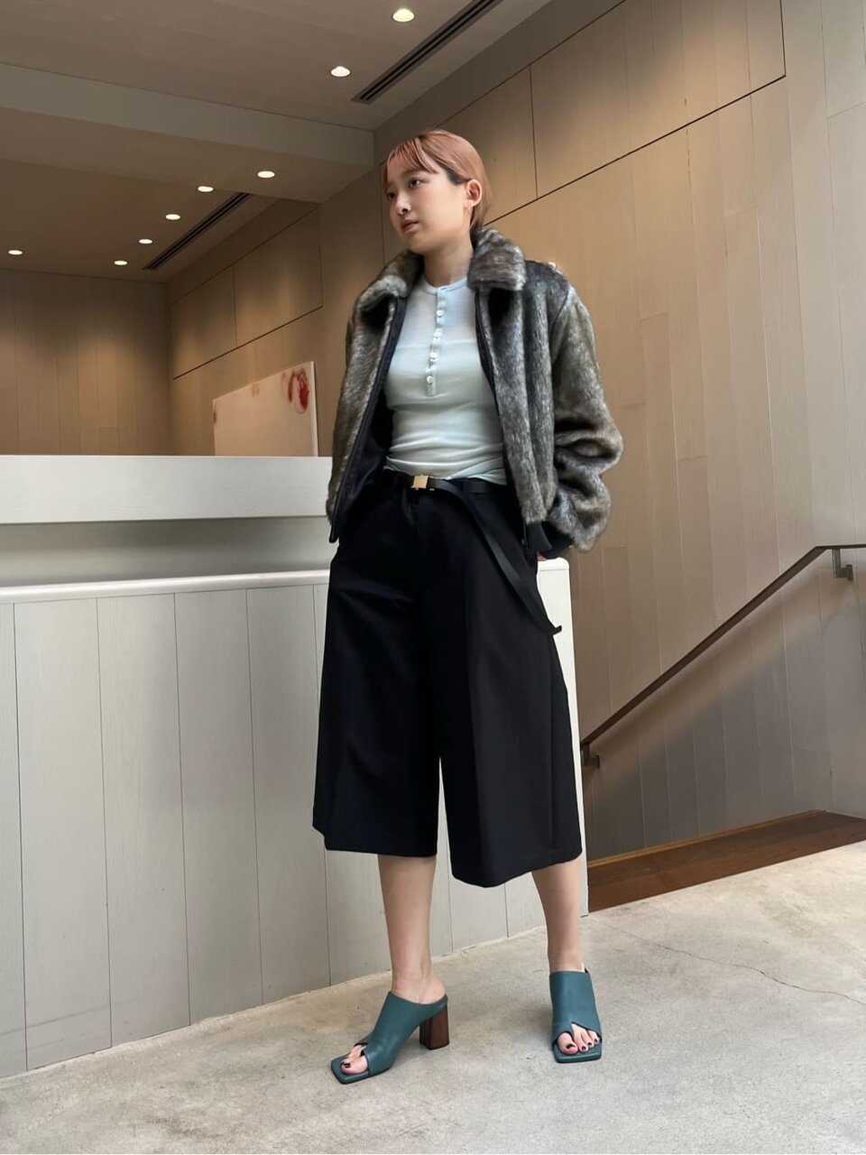 フェイクファーブルゾンとキュロットパンツを着た女性
