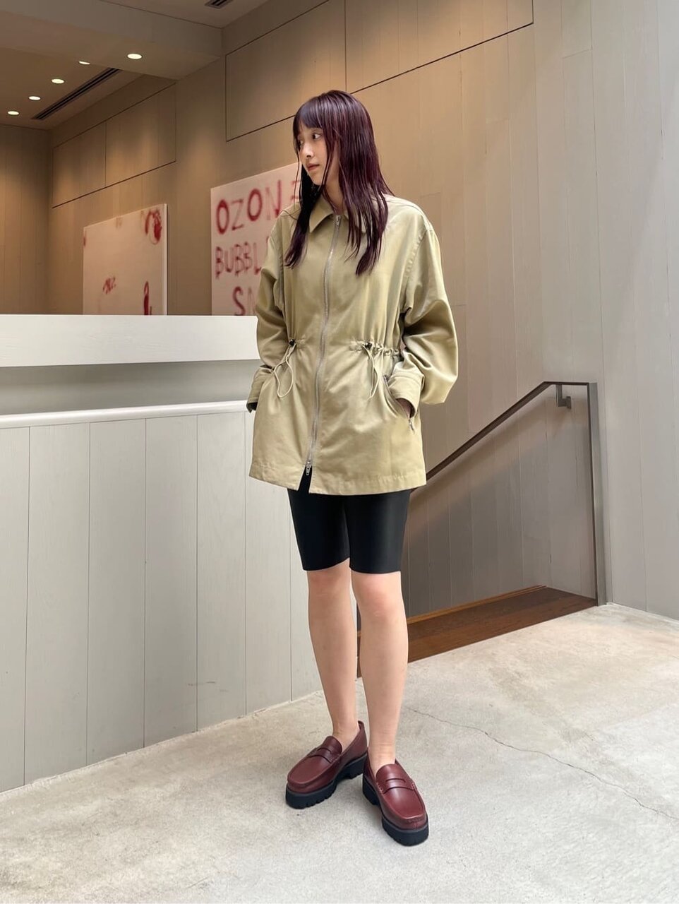 ナイロンツイルブルゾンとバイカーショーツを着た女性