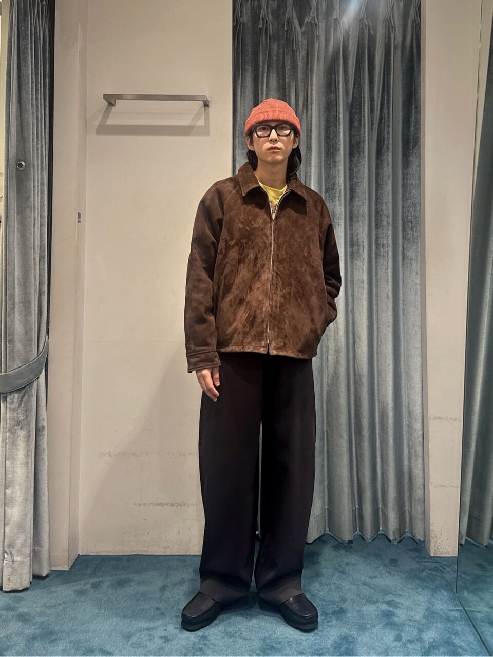 スエードブルゾンとスラックスを着た男性