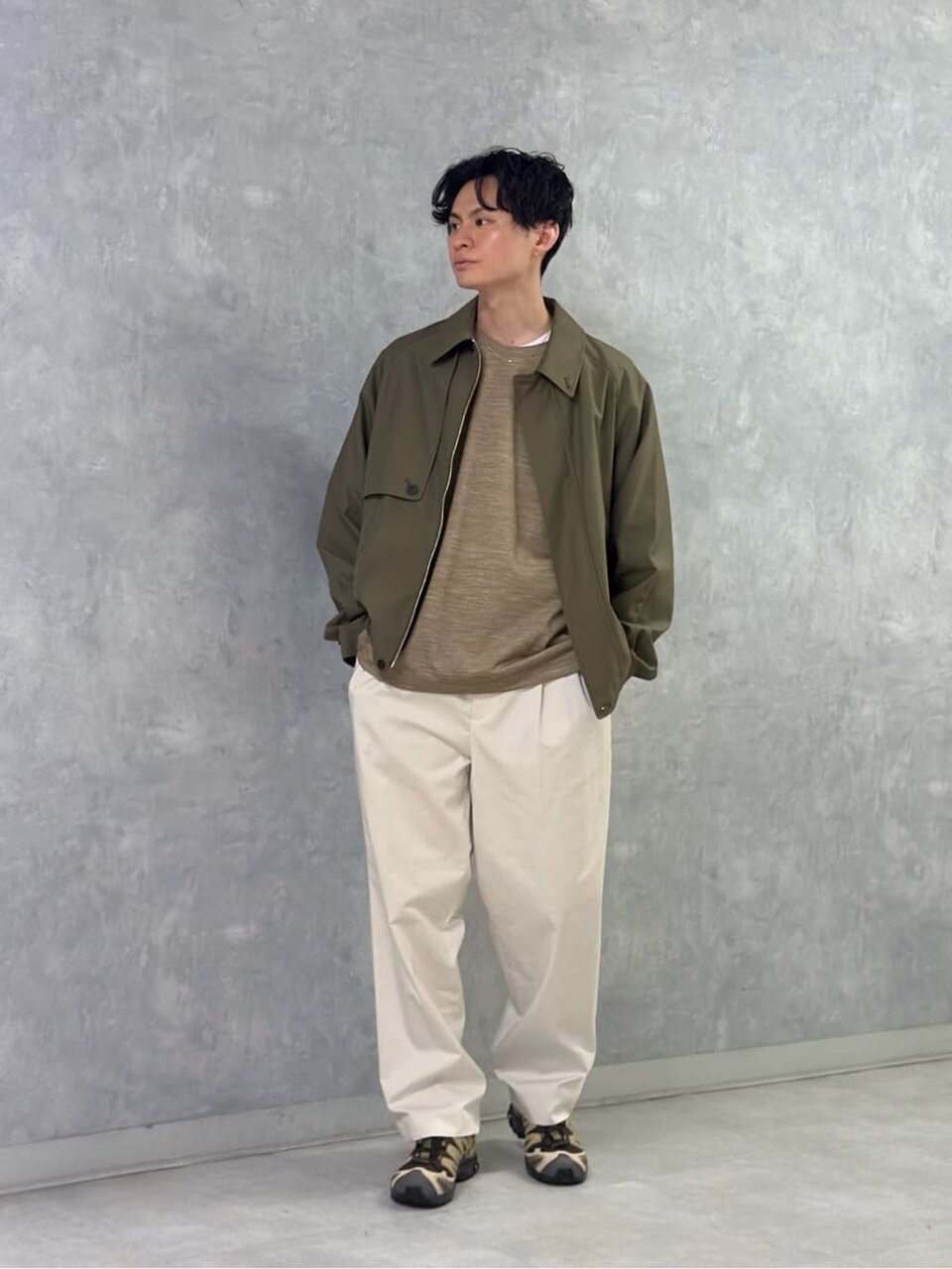 ショートブルゾンとチノパンを着た男性