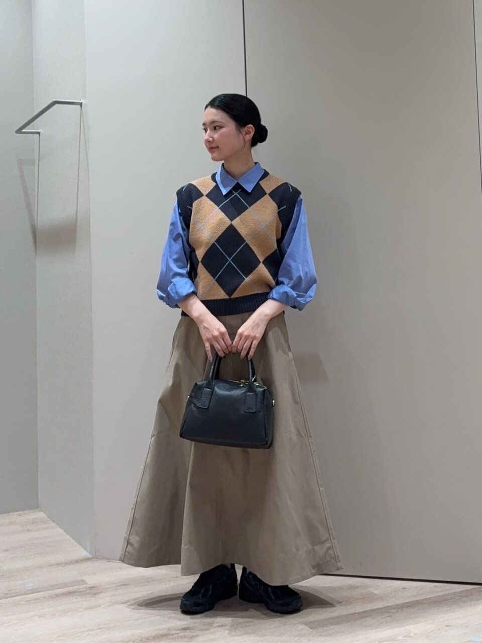 シャツとアーガイルベストを着た女性