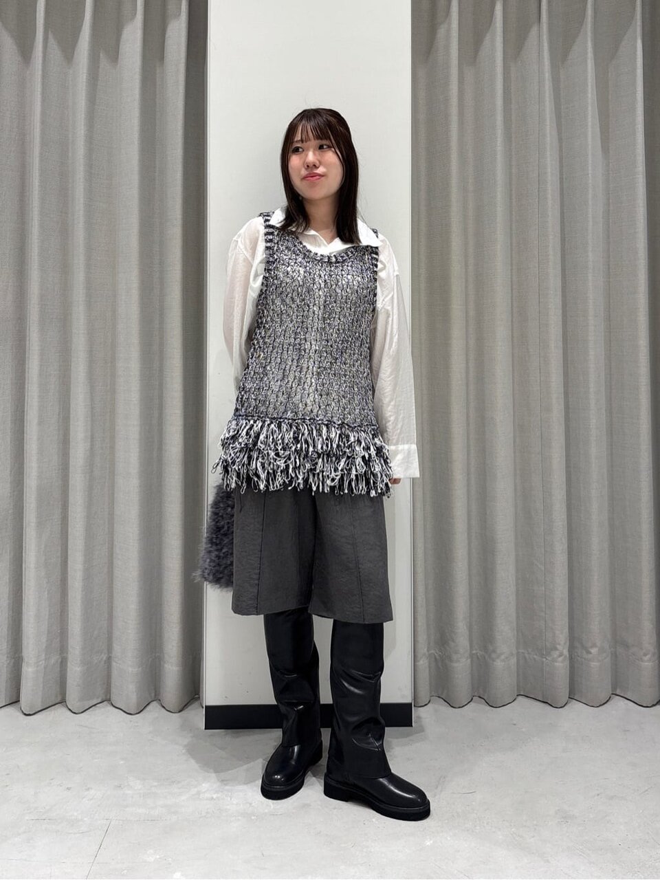 白シャツフェムテックニットベストを着た女性