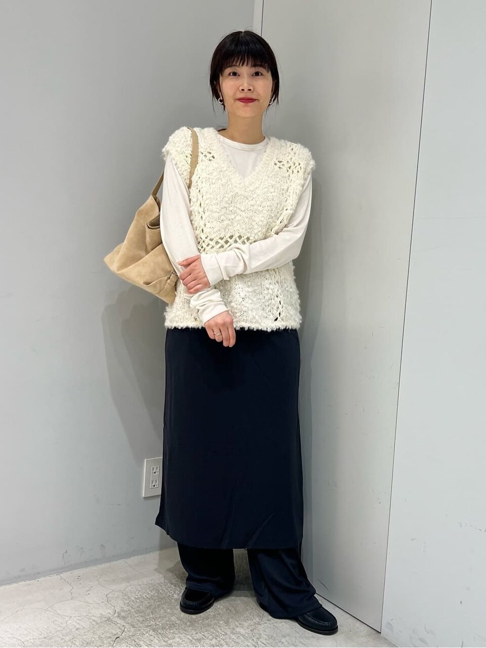 白シャツとニットベストを着た女性