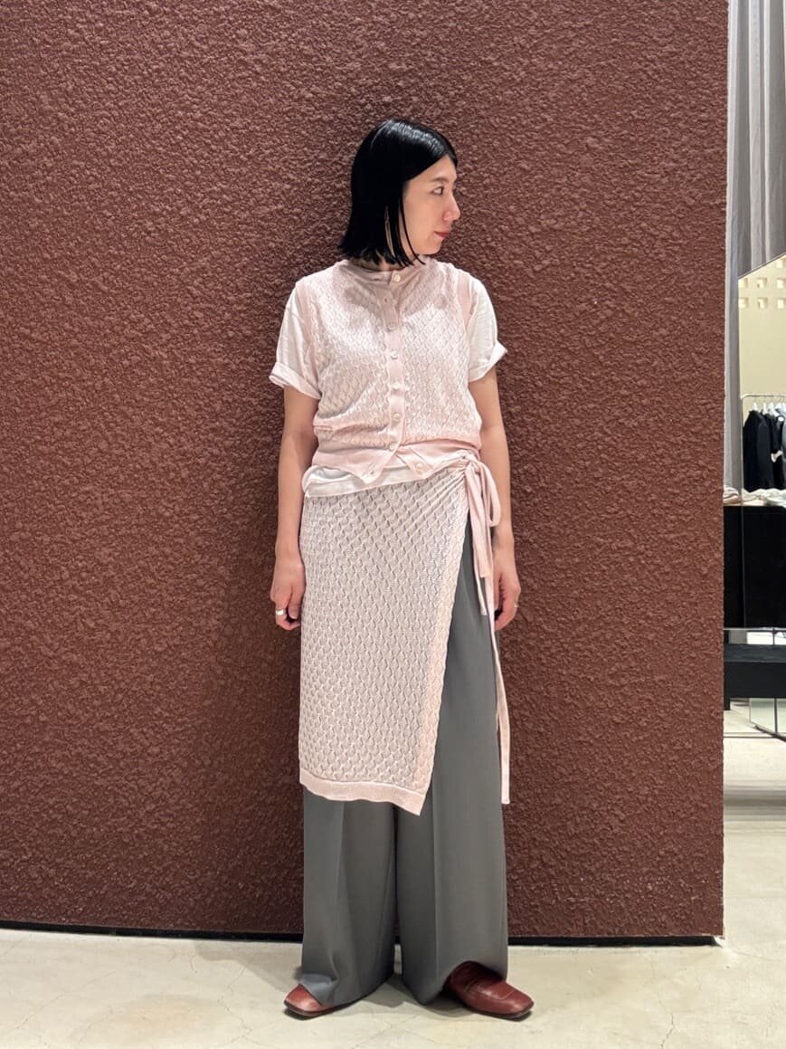 ニットベストと巻きスカートを着た女性