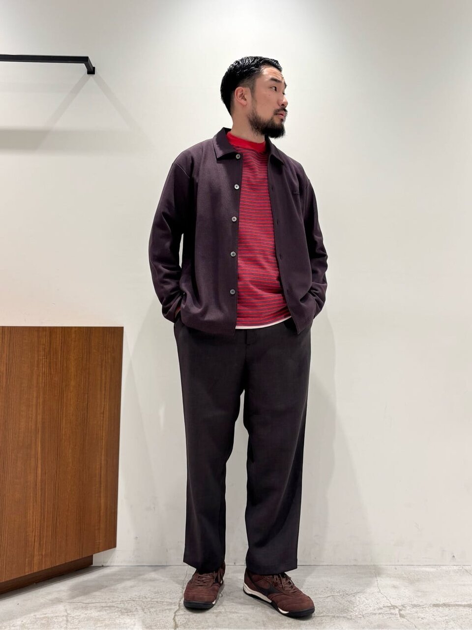 シャツジャケットとテーパードパンツを着た男性