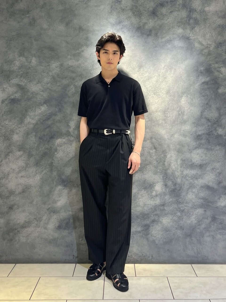 ニットポロとスラックスを着た男性
