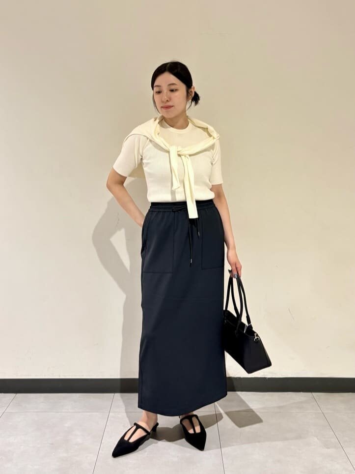 白ニットとタイトスカートを着た女性