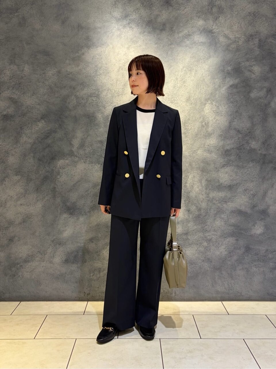 ダブルジャケットと白ニットを着た女性
