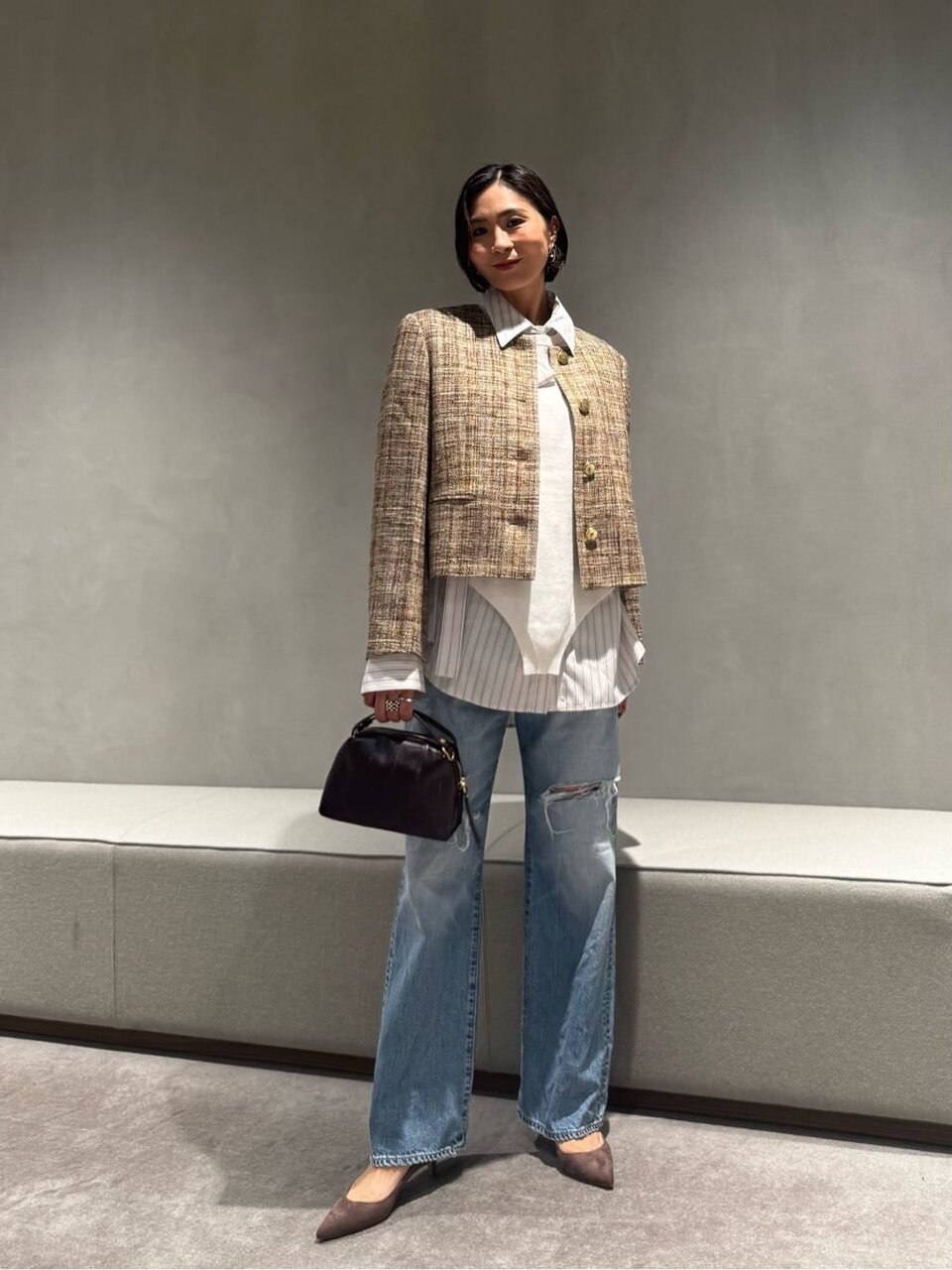 ツイードジャケットと白ニットを着た女性