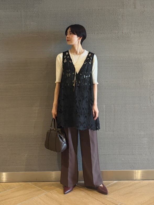 白ニットとレースブラウスを着た女性