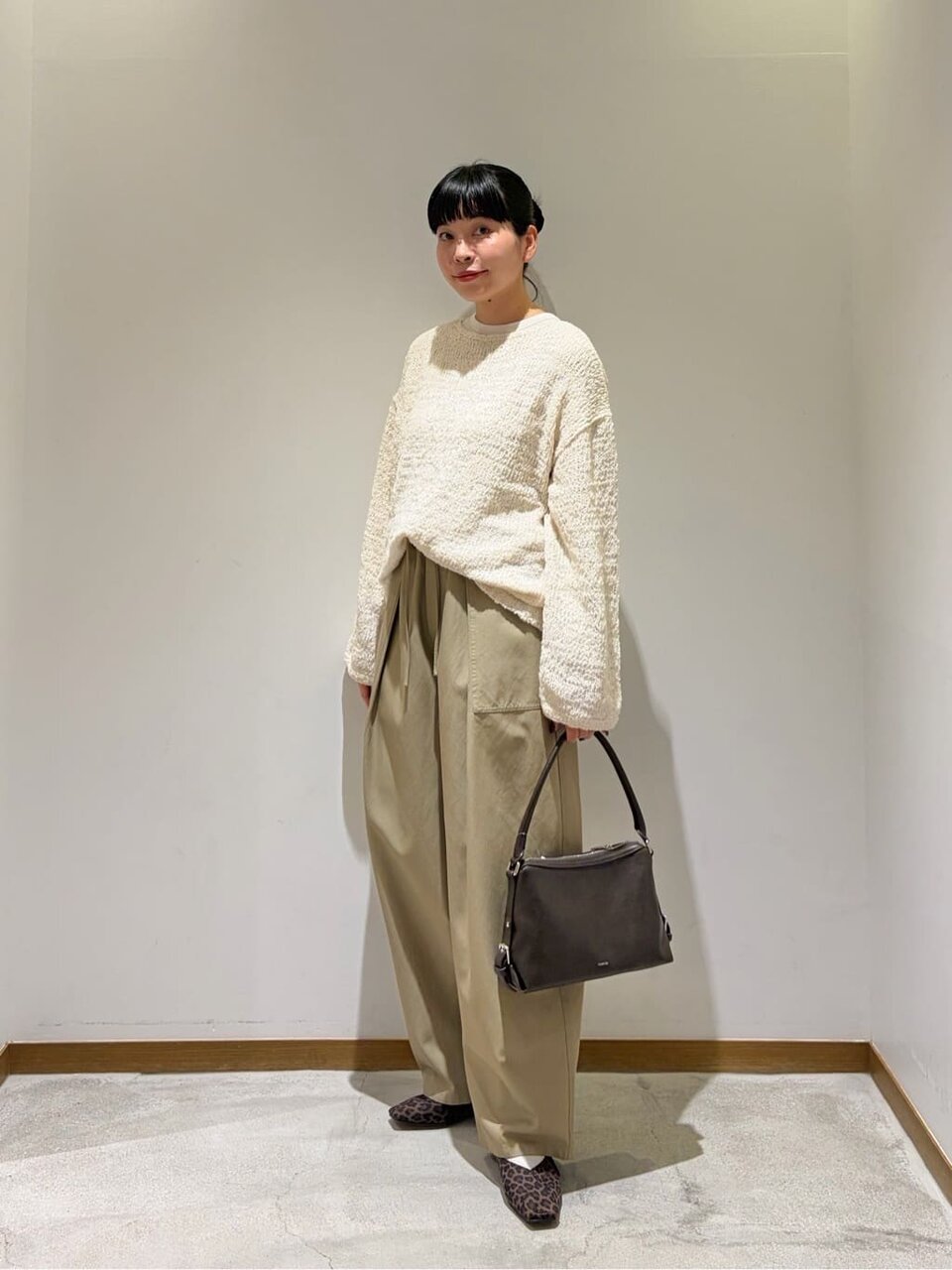 白ニットとオリーブのパンツを着た女性