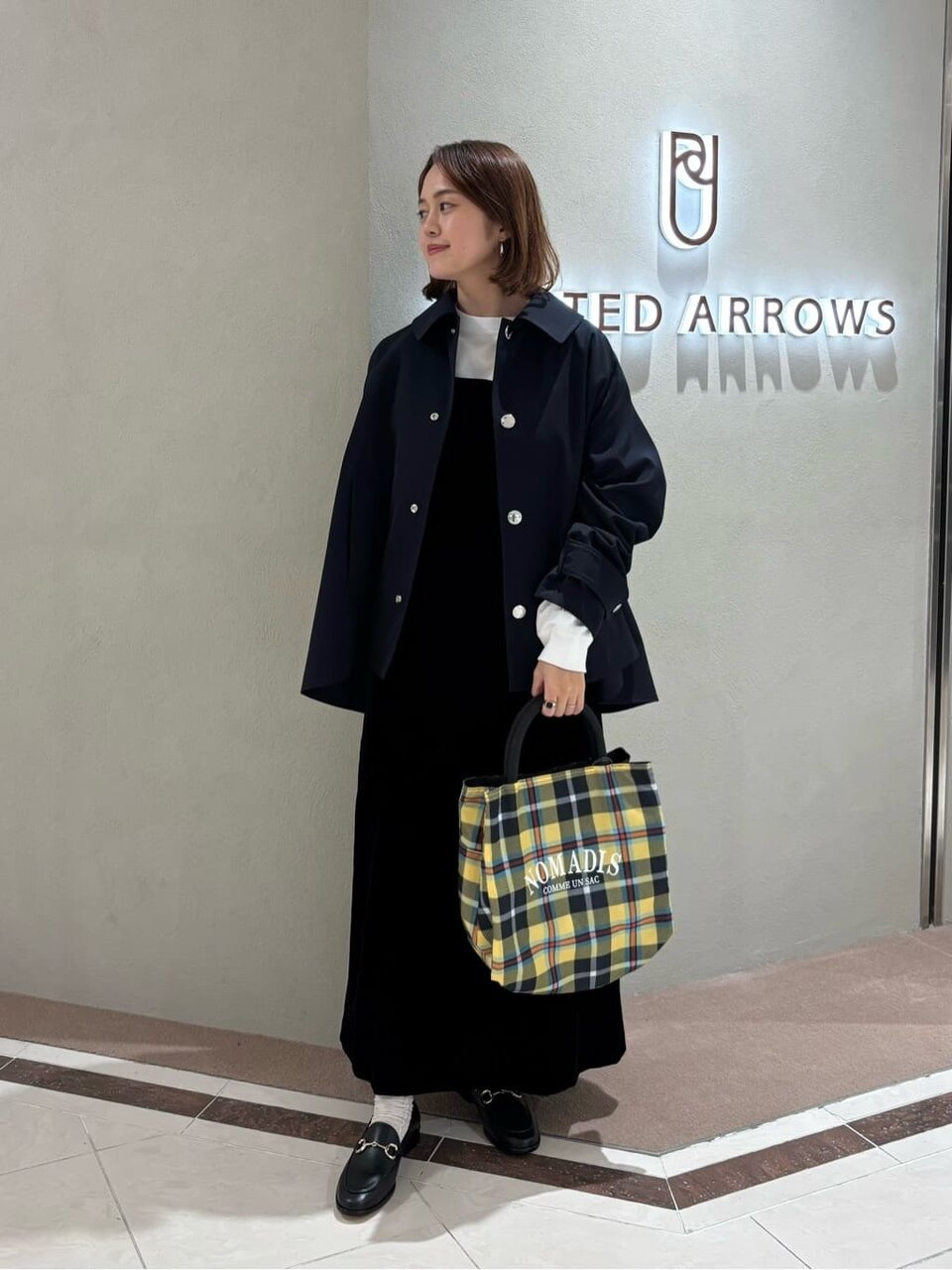 ショート丈のバルマカーンコートを着た女性