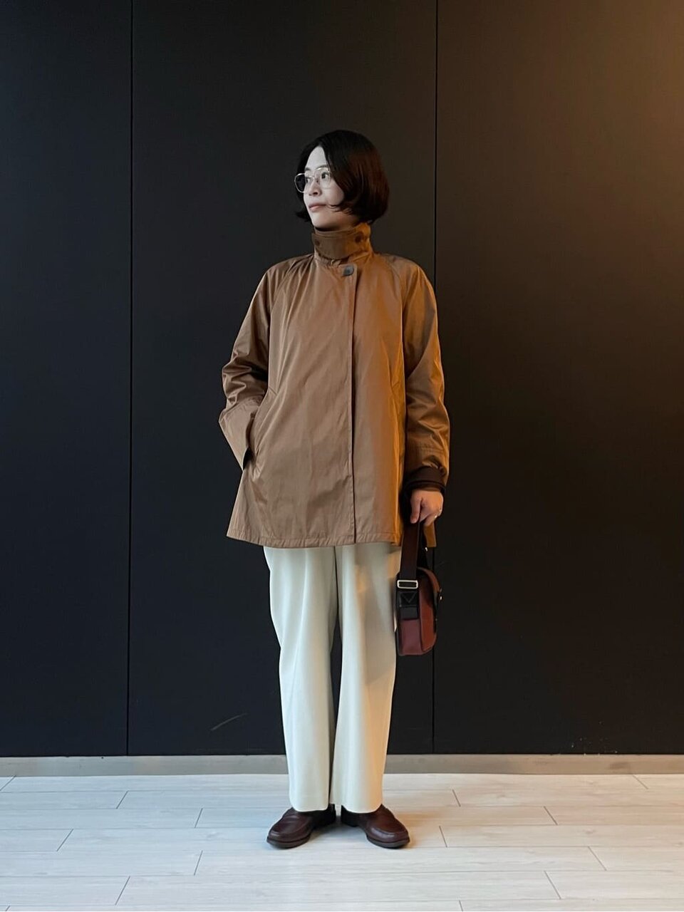 ショート丈のテントコートを着た女性