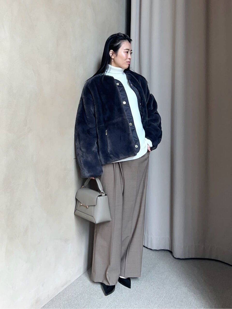 フェイクファーブルゾンとワイドパンツを着た女性