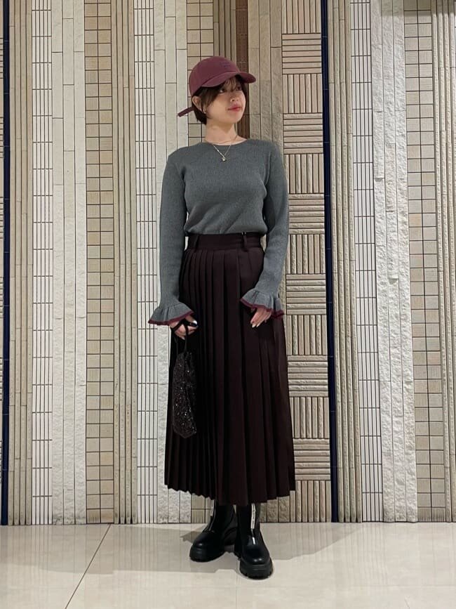 袖口にフリルのついたニットを着た女性